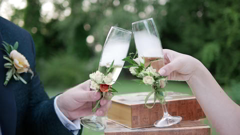 The bride and groom give luck with champagne glasses